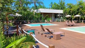 a deck with chairs and a swimming pool with a pool at Exclusiva Casa 18G em Juqueí em Condomínio Resort de Luxo in Juquei