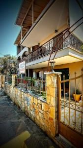 a building with a fence and a balcony at Araxovoli Studios - Aραξοβόλι Lefkada in Tsoukalades