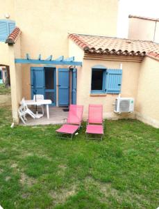 two pink chairs and a table on a yard at Bleu miami in Argelès-sur-Mer
