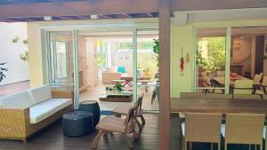 a living room with a couch and a table and chairs at Exclusiva Casa 18G em Juqueí em Condomínio Resort de Luxo in Juquei