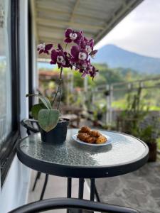 a table with a plate of food and a flower at Uthe house in Pacet