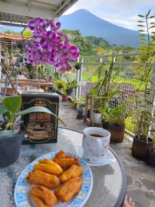 a table with a plate of food and a cup of coffee at Uthe house in Pacet