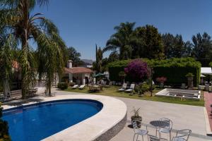 a swimming pool in a yard with chairs and a house at Río Tinto Hotel Boutique in Atlixco