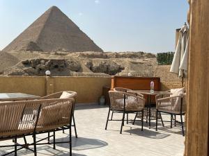 un patio con tavolo, sedie e piramide di Tamara Pyramids View a Il Cairo
