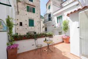 a balcony with two chairs and a table at Casa Amore S Lucia in Amalfi