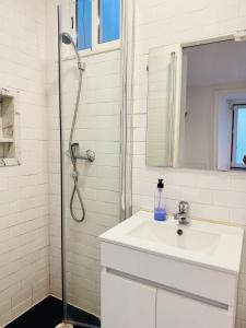 a white bathroom with a sink and a shower at Travessa do Meio Apartment in Lisbon +42 photos