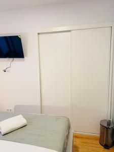 a bedroom with white walls and a bed and a tv at Travessa do Meio Apartment in Lisbon