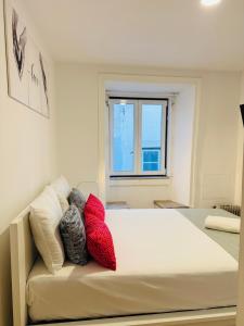 a bedroom with a bed with red and white pillows at Travessa do Meio Apartment in Lisbon