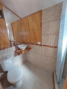 un baño con inodoro y lavabo en Hostal House FloVer, en Puerto Varas