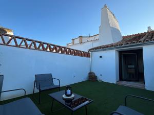 a patio with a table and a white building with a church at MARIDAJE Casa-SPA de enoturismo rural TR-BA-00309 in Fuente del Maestre