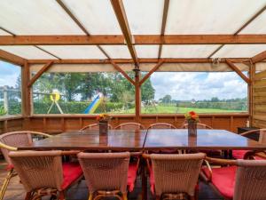 un comedor con mesa y sillas y un parque infantil en Reggezicht, en Hellendoorn