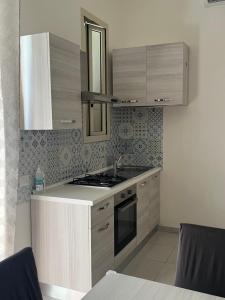 kuchnia ze zlewem i kuchenką górny piekarnik w obiekcie B&B Regina Rooms w mieście Avola