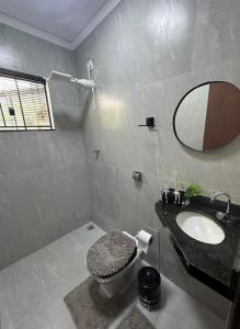 a bathroom with a sink and a toilet and a mirror at Sinta-se em Casa in Cornélio Procópio