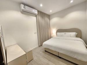a bedroom with a large white bed and a window at شقة جديدة بالقرب من كافد وبوليفارد New Apartment near KAFD and Boulevard in Riyadh +9 photos