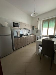 a kitchen with a refrigerator and a table in it at casa Martina - LuxRental Apartments in Pescara
