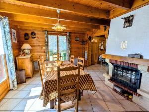 a dining room with a table and a fireplace at Chalet confortable avec 4 chambres, cheminée, grand terrain, proche pistes et lac - FR-1-589-107 in Le Ménil