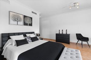 a bedroom with a black and white bed and a chair at Villa Universe in Sant Rafael de Sa Creu +25 photos