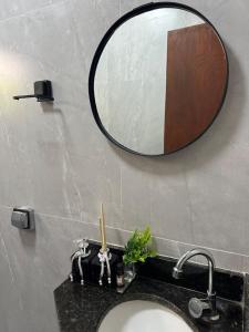 a bathroom sink with a mirror on the wall at Sinta-se em Casa in Cornélio Procópio