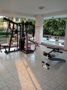 a gym with two treadmills and two chairs in a room at View Talay 1B by Fernando in Pattaya South