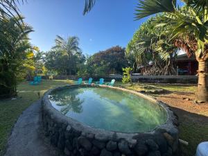 a small swimming pool with chairs in a yard at Blue Moana Lodge in Papara