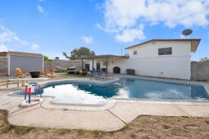 ein Swimmingpool vor einem Haus in der Unterkunft Modern 4BR3Ba Home with Pool and Fire Pit in Phoenix
