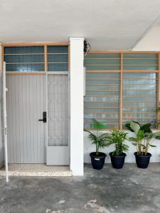 a white garage door with two potted plants at W Home at Jalan Rangoon, George Town Penang in George Town