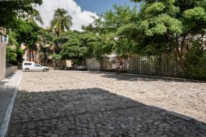 a cobblestone street with a fence and a white car at Departamento Chahué in Santa Cruz Huatulco