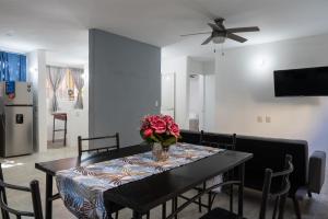 a dining room table with a vase of flowers on it at Departamento Chahué in Santa Cruz Huatulco