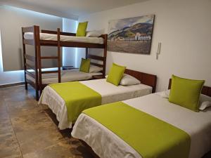a room with two bunk beds with green sheets at Hotel Milán in Duitama +13 photos