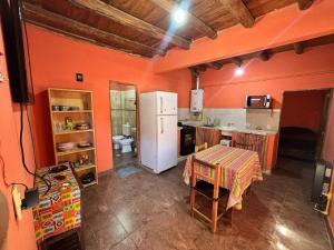 a kitchen with orange walls and a white refrigerator at Suyay Wasi in Purmamarca