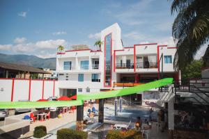 a large white building with a pool and a green slide at Bora Beach Club in Melgar