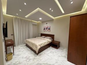 a bedroom with a bed and a television in it at شقة فندقية في المهندسين جامعة الدول in Cairo