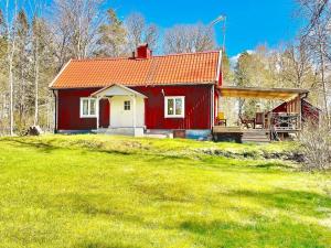 a red house with a red roof on a grass field at 5 person holiday home in Mörlunda in Mörlunda +18 photos
