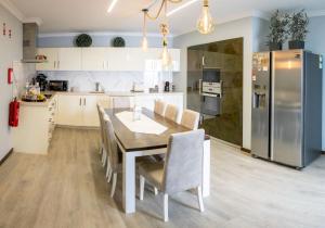 a kitchen with a table and chairs and a refrigerator at The Spot - ilha de São Miguel (Povoação) Açores in Povoação