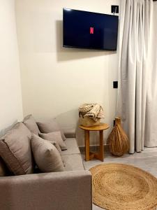 a living room with a couch and a tv on the wall at Angatu Chales Alma Boa in Serra Negra