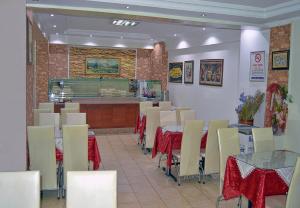 ein Restaurant mit Tischen und Stühlen und einer Theke in der Unterkunft Yunus Hotel in Gaziantep