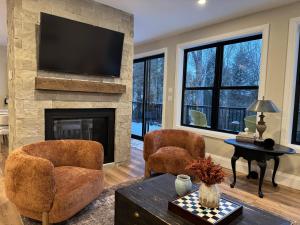 a living room with two chairs and a fireplace at Algonquin Park,Sunset Paradise with Private Beach in Madawaska