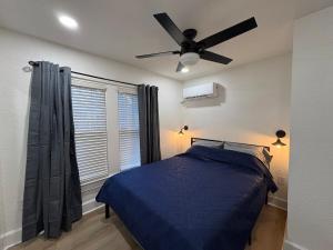 a bedroom with a blue bed and a ceiling fan at Downtown Zen 2-Bedrooms Private Bungalow in St Petersburg