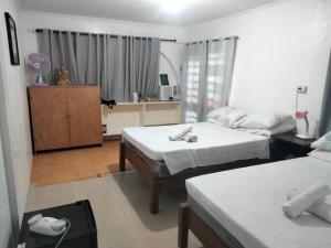 a bedroom with two beds and a dresser in it at SEASCAPE in Moalboal