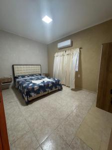a bedroom with a bed and a window at NEKZA TEMPORARIOSs in Resistencia