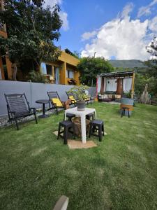 a group of benches and a table in a yard at Villa Pella - Chalé Tulipa- com café manhã in Brumadinho