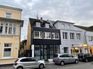 two cars parked in a parking lot in front of a building at Ostsee Ferienwohnung Möwengasse in Travemünde