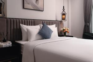 a bedroom with a large bed with white pillows at 22Land Cloud Hotel in Hanoi