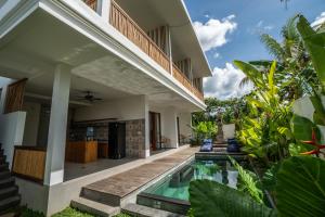 una vista esterna di una villa con piscina di Kemari Ubud ad Ubud