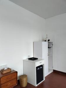 Una cocina con estufa y refrigerador blanco. en Three Octopus by Walidwipa Paradise Hospitality, en Uluwatu