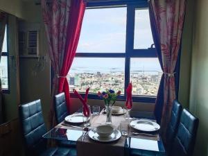 a dining room table with a view of a city at MaehwensStaycation in Cebu City