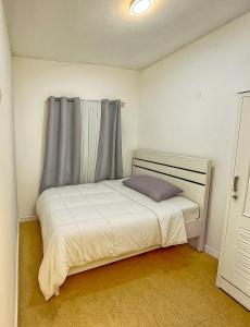 una piccola camera da letto con un letto bianco e una finestra di Platinum Pavilion a Dubai Altre 8 foto