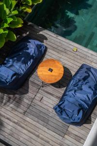 a raft and a table on a deck next to a pool at Kemari Ubud in Ubud