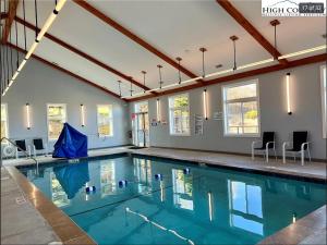 a swimming pool with blue water in a building at The Sugar Suite - Renovated with a View! Ski IN-OUT! Heated POOL, Hot tub, sauna, gym, AC, EV, adjustable bed in Sugar Mountain