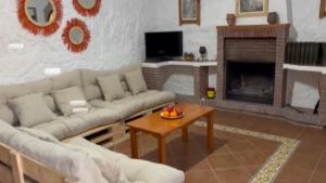 a living room with a couch and a table and a fireplace at Bike Cueva Gorafe in Gorafe